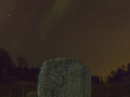 Rune stone, northern light and ambient city light, Sweden